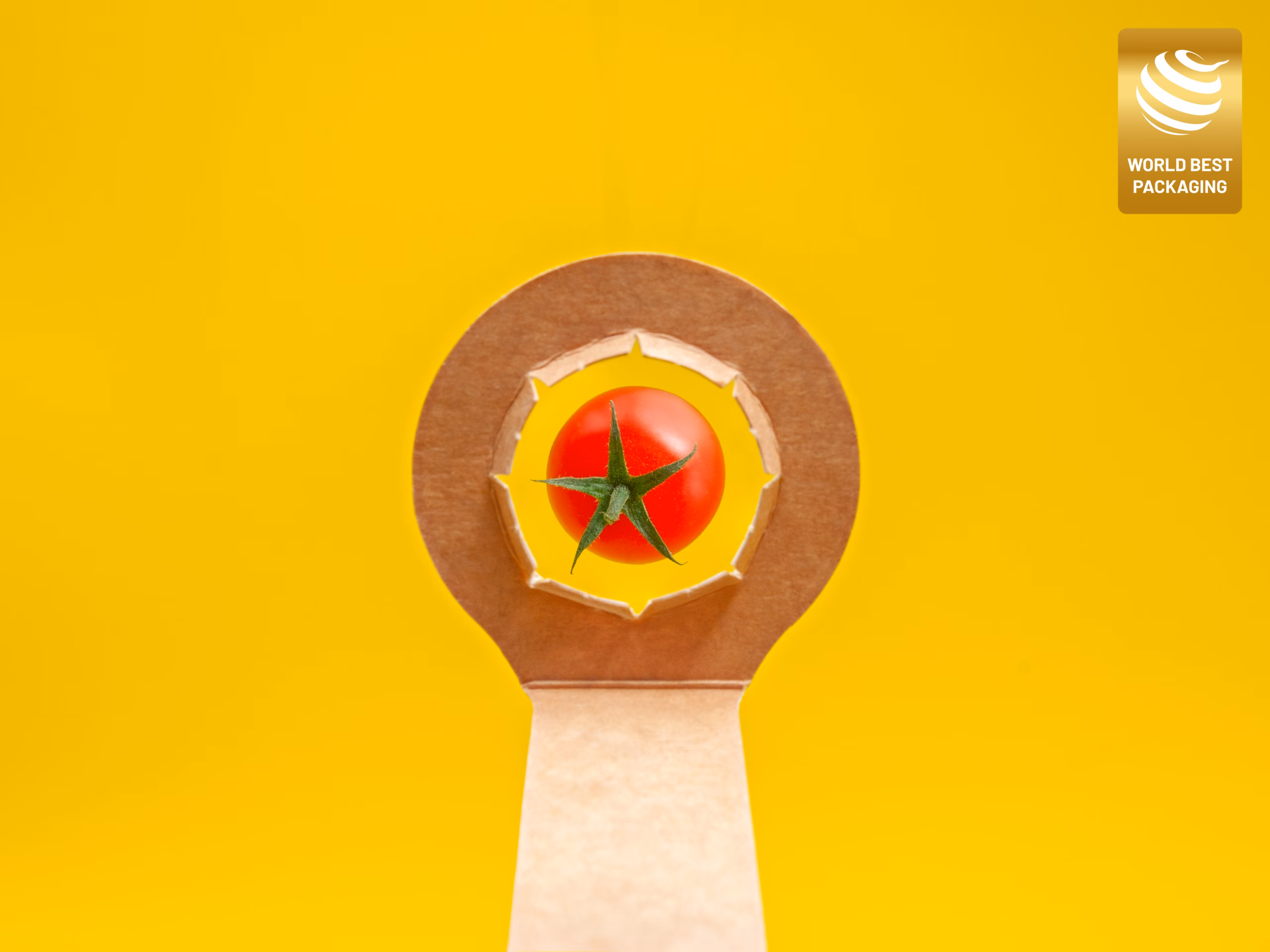 Detalle del aro troquelado en cartón kraft de la barqueta ENBOX con tomate cherry, diseño ganador del Gold World Best Packaging 2026